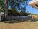 View of the backyard, featuring a tree, grass and wooden fence for privacy at 2802 Jamaica St, Sarasota, FL 34231