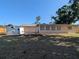 Back exterior view of home with landscaping, storage shed, and a patio dining area at 2802 Jamaica St, Sarasota, FL 34231