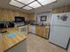Functional kitchen with oak cabinetry, white appliances, and ample counter space for meal preparation at 2802 Jamaica St, Sarasota, FL 34231