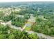 Aerial view showcasing the property's location on a wooded lot at 343 Tenk St, Port Charlotte, FL 33953