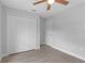 Bedroom with wood-look tile flooring, closet and entry doors, and a ceiling fan at 343 Tenk St, Port Charlotte, FL 33953