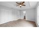 A bright bedroom featuring wood-look tile flooring, a ceiling fan, and an ensuite bathroom at 343 Tenk St, Port Charlotte, FL 33953