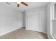 Bedroom with wood-look tile flooring, closet and entry doors, and a ceiling fan at 343 Tenk St, Port Charlotte, FL 33953