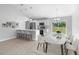 Open-concept kitchen and dining area with white cabinets, breakfast bar, and stainless steel appliances at 343 Tenk St, Port Charlotte, FL 33953