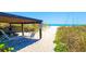 Scenic beach access with shaded seating area and inviting pathway to the white sand beach at 3740 Gulf Of Mexico Dr # 116, Longboat Key, FL 34228