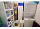 Organized laundry area with shelving, including washer, dryer, and storage for cleaning and household supplies at 3740 Gulf Of Mexico Dr # 116, Longboat Key, FL 34228