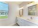 Bathroom featuring a double vanity with undermount sinks and modern gold fixtures at 380 Holly Rd, Venice, FL 34293