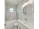 Elegant bathroom featuring a bathtub and shower combination, decorative mirror, and modern sink with storage at 380 Holly Rd, Venice, FL 34293