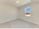 Bright bedroom with a window providing natural light and stylish marble-look tile floors at 380 Holly Rd, Venice, FL 34293