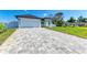 Beautiful home featuring a long, patterned driveway and a well-manicured lawn under a clear blue sky at 380 Holly Rd, Venice, FL 34293