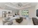 Open-concept living room featuring modern décor, a ceiling fan, and sliding glass doors to the outdoors at 380 Holly Rd, Venice, FL 34293