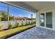 A rear outdoor patio with pavers, newly planted bushes, and a view to the neighborhood at 380 Holly Rd, Venice, FL 34293