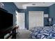 Cozy bedroom featuring blue walls, plush carpeting, and a closet with bi-fold doors at 3806 155Th E Ave, Parrish, FL 34219