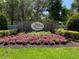Stone sign for Twin Rivers community with colorful flowers and manicured landscaping at 3806 155Th E Ave, Parrish, FL 34219