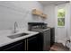 Well-equipped laundry room with front-loading washer and dryer, sink and overhead storage at 3806 155Th E Ave, Parrish, FL 34219