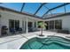 Inviting pool area featuring a screened enclosure, tropical landscaping, and ample seating at 3806 155Th E Ave, Parrish, FL 34219