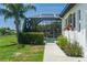 Manicured lawn with a screened pool enclosure and tropical landscaping accents at 3806 155Th E Ave, Parrish, FL 34219