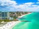 Stunning aerial view of beach condos along the white sand beach and vibrant turquoise ocean water at 4122 Central Sarasota Pkwy # 1923, Sarasota, FL 34238