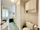 Bathroom featuring cabinet storage, toilet, and entrance to bedroom with natural lighting at 4122 Central Sarasota Pkwy # 1923, Sarasota, FL 34238