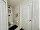Cozy bathroom featuring a toilet, white door, linen closet, and floral wall decor at 4122 Central Sarasota Pkwy # 1923, Sarasota, FL 34238