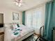 Bright bedroom with large window, ceiling fan, and decorative blue accents at 4122 Central Sarasota Pkwy # 1923, Sarasota, FL 34238