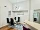 Dining area with a modern chandelier, a glass table with seating for four, and stylish decor at 4122 Central Sarasota Pkwy # 1923, Sarasota, FL 34238