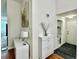 Entryway featuring two white cabinets, a decorative butterfly, and a bathroom in the background at 4122 Central Sarasota Pkwy # 1923, Sarasota, FL 34238