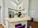 Open concept kitchen with white cabinets, breakfast bar, and views into the living area at 4122 Central Sarasota Pkwy # 1923, Sarasota, FL 34238