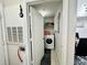Laundry room featuring a washing machine, shelving, and a doorway to the dining area at 4122 Central Sarasota Pkwy # 1923, Sarasota, FL 34238