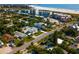 An aerial view of a lush neighborhood with homes, palm trees, and beachside condos in the distance at 4122 Central Sarasota Pkwy # 1923, Sarasota, FL 34238