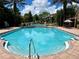 A bright blue community pool with an access ramp, fountains, and lots of seating at 4122 Central Sarasota Pkwy # 1923, Sarasota, FL 34238
