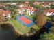Aerial view of a tennis court next to a picturesque pond and well-maintained landscaping at 4122 Central Sarasota Pkwy # 1923, Sarasota, FL 34238