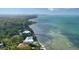 Breathtaking aerial view of a waterfront property with a modern home, pool, and lush greenery at 4123 Bay Shore Rd, Sarasota, FL 34234