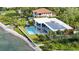 Luxury waterfront home featuring solar panels, pool, outdoor kitchen, and lush landscaping at 4123 Bay Shore Rd, Sarasota, FL 34234