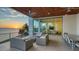 A covered balcony with beautiful sunset views, dining space, and lounging area at 4123 Bay Shore Rd, Sarasota, FL 34234