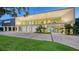 Modern home with a wall of windows, a spacious driveway, and lush green lawn at 4123 Bay Shore Rd, Sarasota, FL 34234