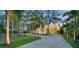 View of home with a large driveway framed by lush trees and landscaping at 4123 Bay Shore Rd, Sarasota, FL 34234