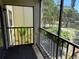 Screened balcony offering serene views of tropical foliage and a pond at 425 30Th W Ave # C204, Bradenton, FL 34205