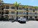 Three-story condo building featuring assigned parking and tropical landscaping at 425 30Th W Ave # C204, Bradenton, FL 34205