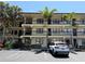 Three-story condo building boasts black iron balconies, beige exterior, and reserved parking spaces at 425 30Th W Ave # C204, Bradenton, FL 34205