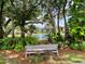 Scenic view of a pond with a gazebo, surrounded by lush greenery, with a bench in the foreground at 425 30Th W Ave # C204, Bradenton, FL 34205