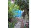 Backyard featuring tropical vegetation, a gravel walkway, and a storage shed at 4700 Neptune Rd, Venice, FL 34293