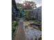 Backyard featuring a rock garden with water feature and a stone walkway surrounded by greenery at 4700 Neptune Rd, Venice, FL 34293