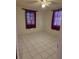 Empty bedroom showcasing white tile flooring, ceiling fan, and curtained windows at 4700 Neptune Rd, Venice, FL 34293
