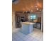 Bright kitchen features stainless steel appliances, island, and custom wood ceiling at 4700 Neptune Rd, Venice, FL 34293