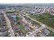 A wide aerial perspective of a residential area featuring a pond, organized street pattern, and lush green landscapes at 4826 San Ortebello Dr, Bradenton, FL 34208