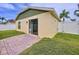 Backyard featuring a green lawn, stucco walls, and a sliding glass door to paved patio at 4826 San Ortebello Dr, Bradenton, FL 34208