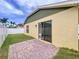 Backyard featuring a green lawn, stucco walls, and a sliding glass door to paved patio at 4826 San Ortebello Dr, Bradenton, FL 34208