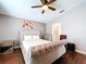 This main bedroom has a decorative headboard, ceiling fan and hardwood floors at 4826 San Ortebello Dr, Bradenton, FL 34208