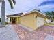 A charming single-Gathering home featuring a colorful exterior, a well-maintained lawn, and a brick-paved driveway at 4826 San Ortebello Dr, Bradenton, FL 34208